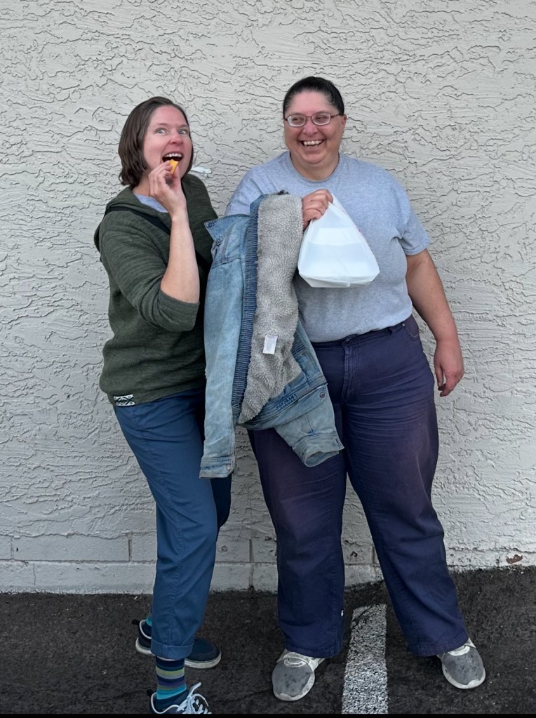The Writer and their Younger Sis outside local Chinese restaurant. Both are wearing casual clothes and Younger sister is mugging at the camera. 